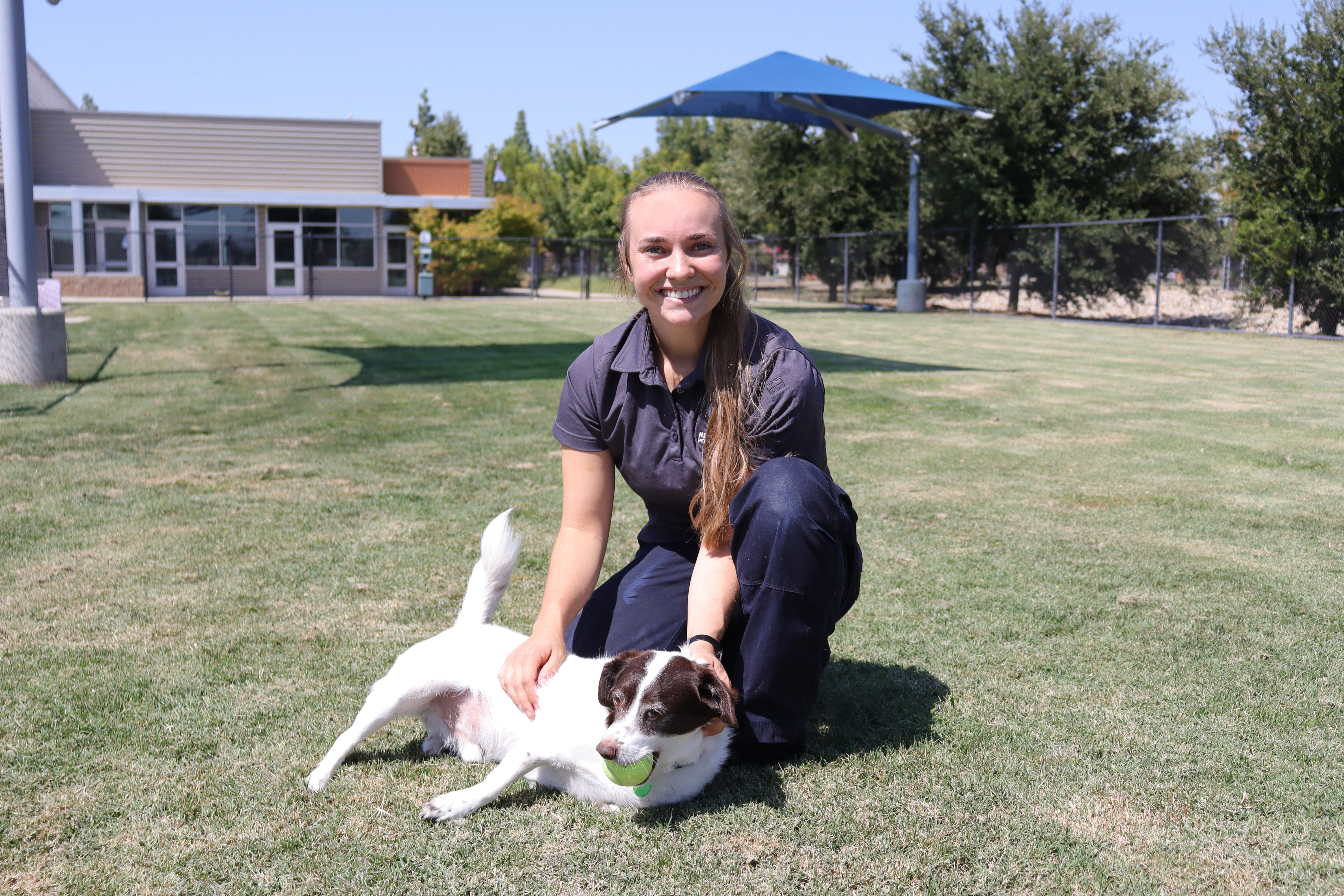 Woman petting terrier dog in yard at Miss Winkles