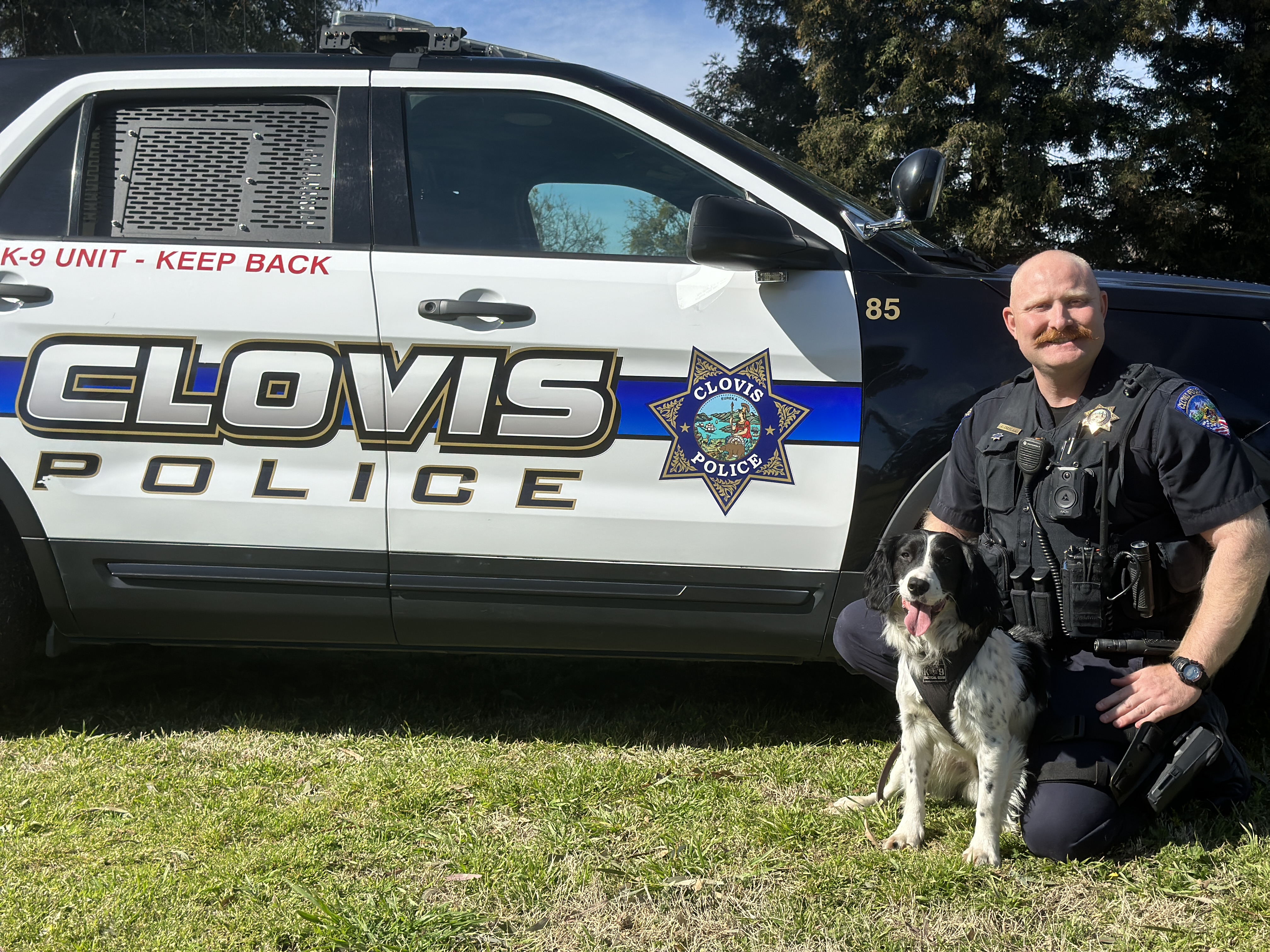 Clovis Police Officer kneeling with K-9