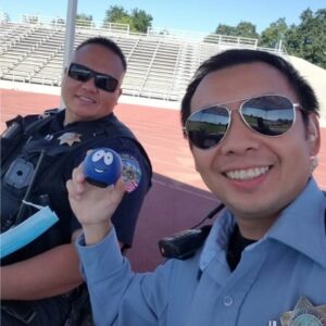 Clovis Police officer holding a stress ball giveaway item